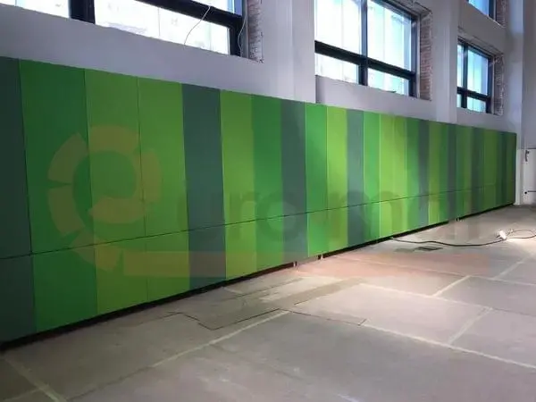 Зелёные стеновые протекторы в полоску разных оттенков вдоль длинной стены спортзала