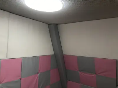 Детальный вид розово-серых стёганых протекторов и белых верхних панелей в детской комнате