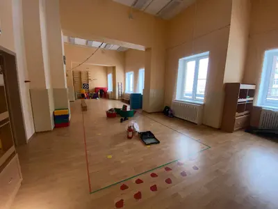 Бежевые стеновые протекторы на стенах и колоннах спортзала детского сада с гимнастическими брусьями