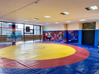 Борцовский ковер и протекторы с портретами чемпионов Карелина и Власова в зале в Липецке