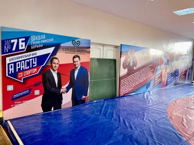 Протекторы с логотипами "Зал №76", "Я расту со спортом" и "Сердце лидера" в зале борьбы в Липецке