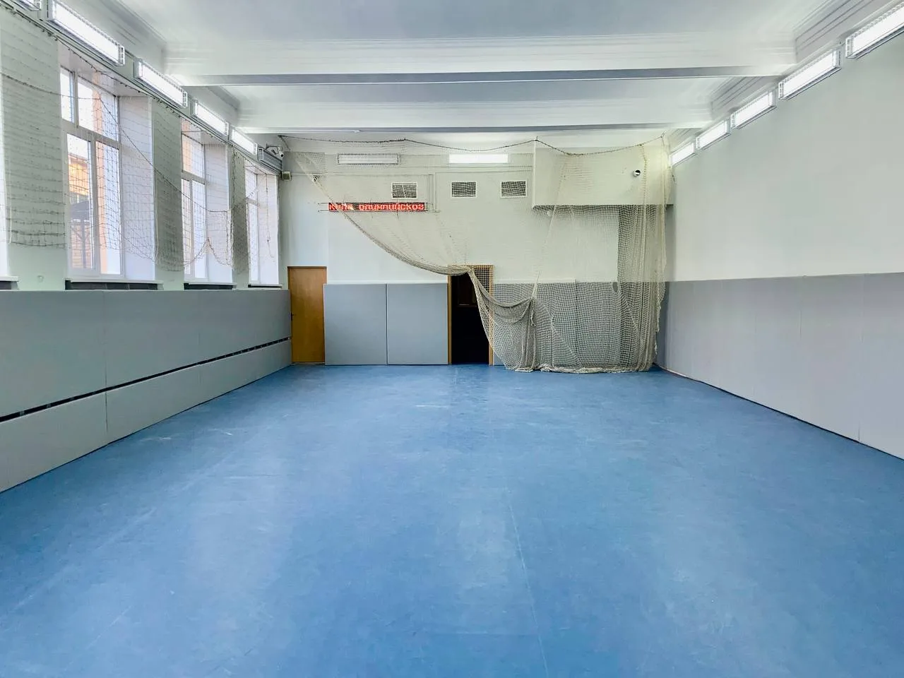 Серые стеновые протекторы в спортзале Московской футбольной академии с синим резиновым полом