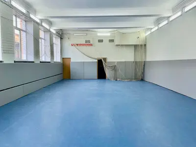 Серые стеновые протекторы в спортзале Московской футбольной академии с синим резиновым полом