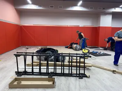 Красно-оранжевые стеновые протекторы и серые татами на полу в зале Новой школы, вид сверху