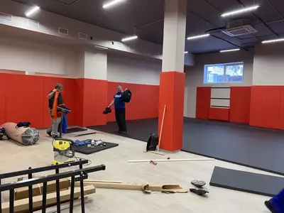 Красные стеновые протекторы и серые татами в зале Новой школы — общий вид зала