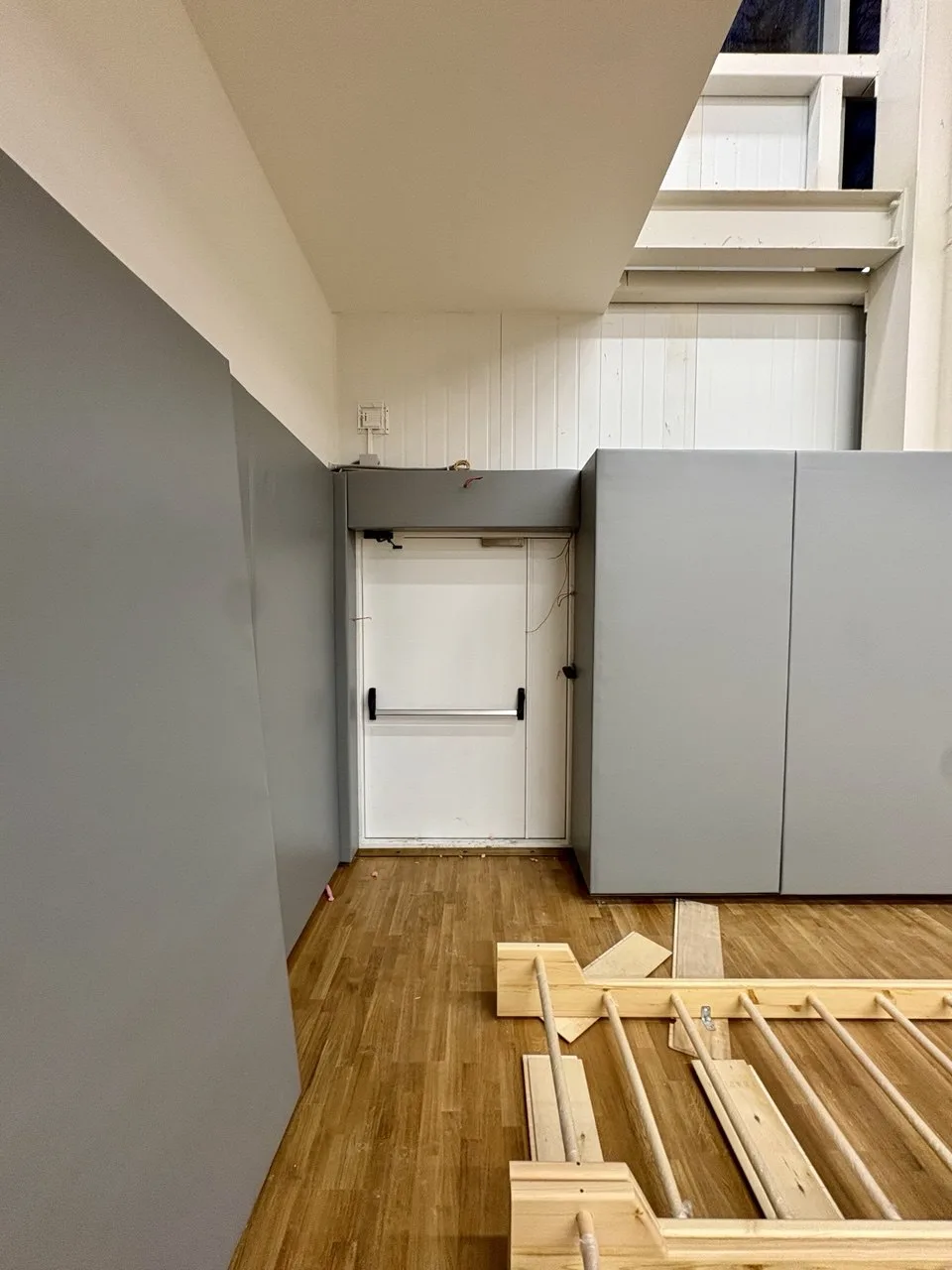 Серые протекторы в углу спортзала с дверным проёмом, монтаж на липучке