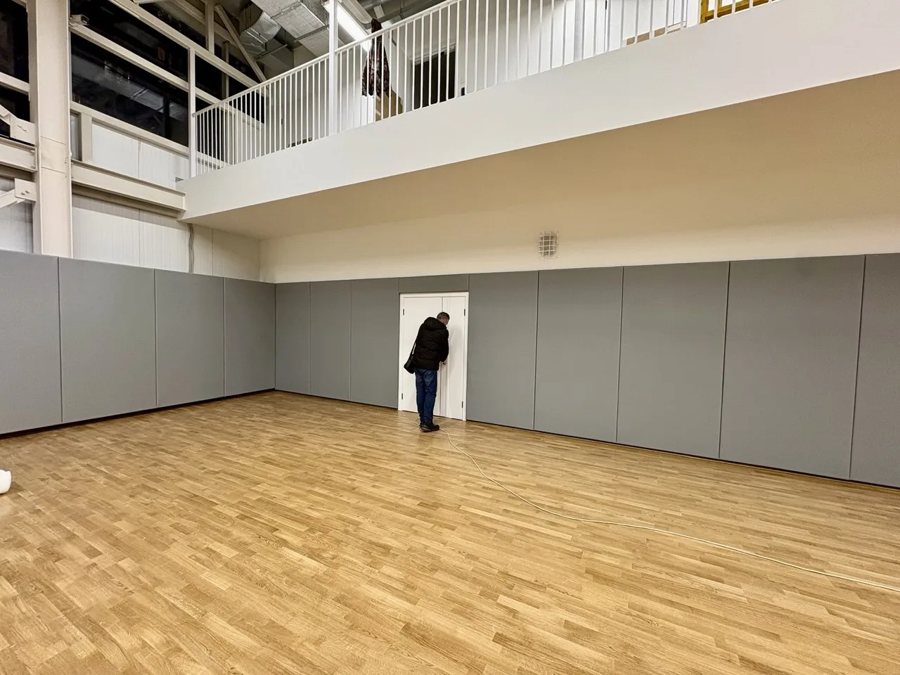 Завершённый результат: стена полностью защищена серыми протекторами, видна маленькая дверь и балкон