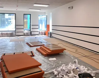 Оранжевые стеновые протекторы на полу с полосами велькро, подготовка стен к монтажу в школе Снегири