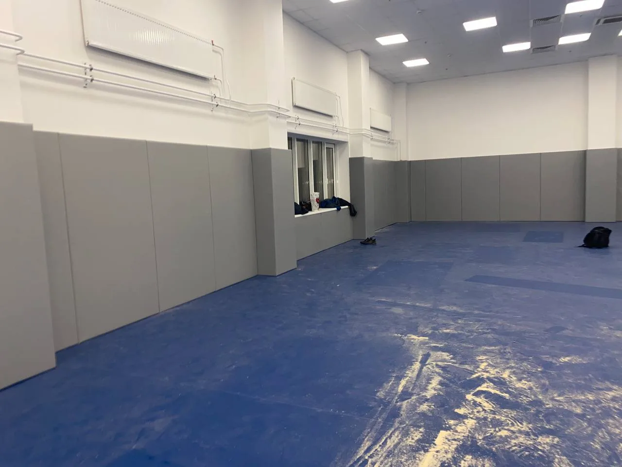 Второй тренировочный зал с синими татами и серыми протекторами по периметру