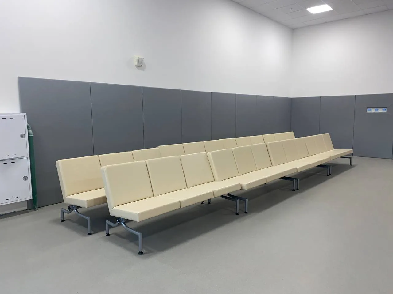 Вид сверху на тренировочный зал: равномерная укладка синих татами, стены обшиты серыми протекторами