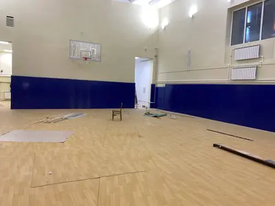 Второй спортзал школы Няндома с синими протекторами, баскетбольным щитом и радиаторами отопления