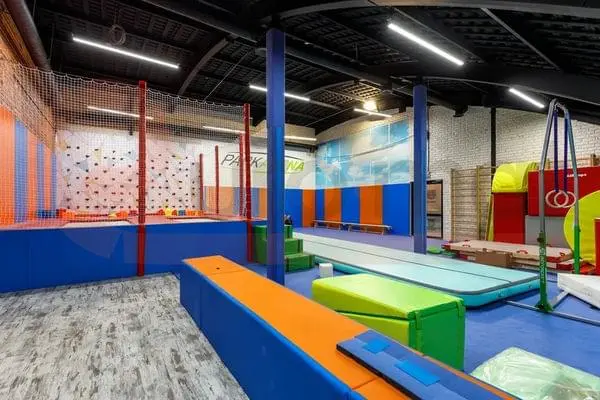 Стеновые протекторы синего и оранжевого цвета в Park Arena Москва — гимнастическая зона с матами и скалодромом