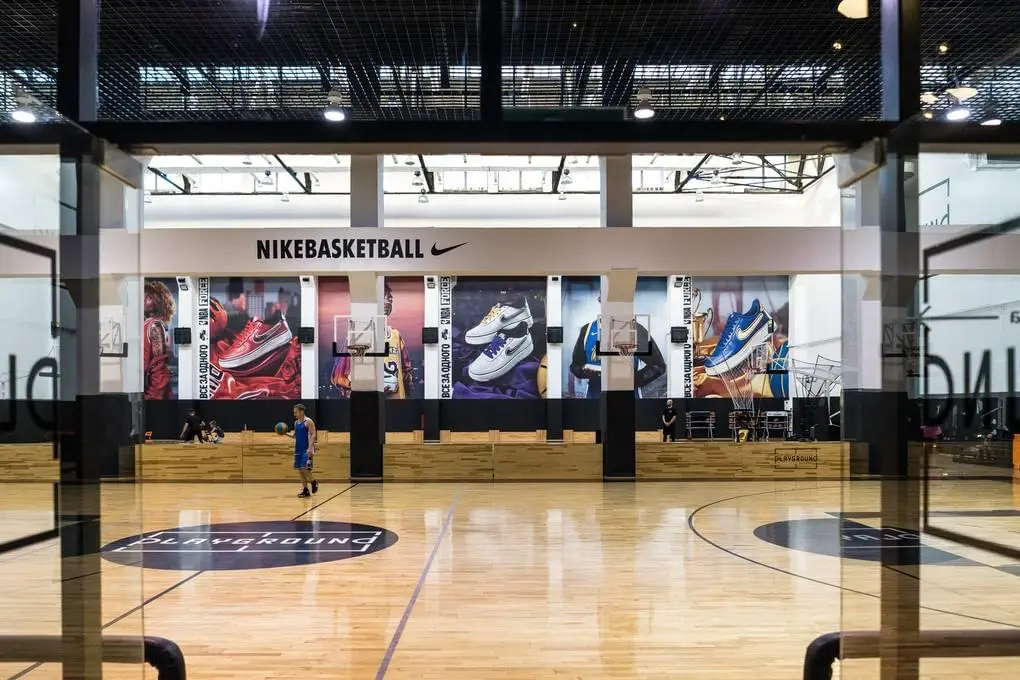 Чёрные стеновые протекторы в баскетбольной арене Nike Playground, вид через стекло
