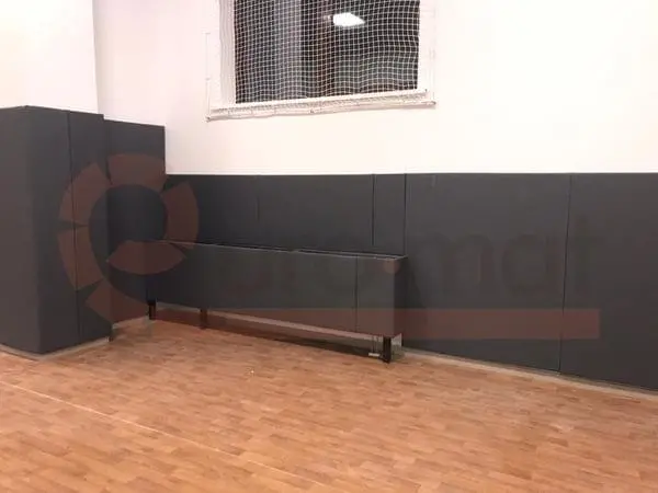 Тёмно-серые стеновые протекторы с обшивкой колонны и защитой радиатора в школьном спортзале
