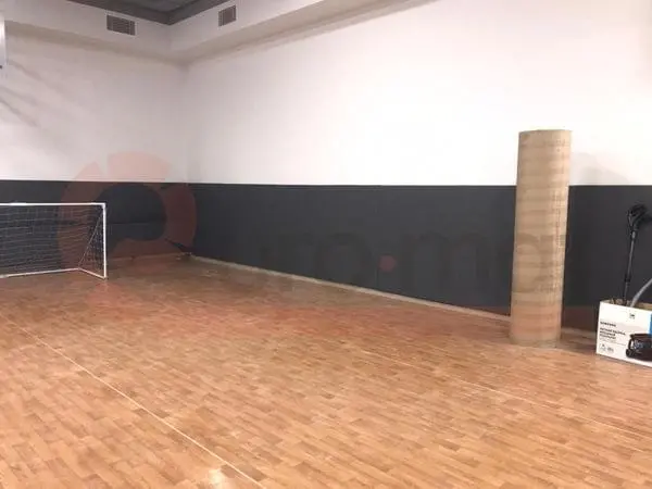 Тёмно-серые стеновые протекторы вдоль стены школьного спортзала с мини-футбольными воротами