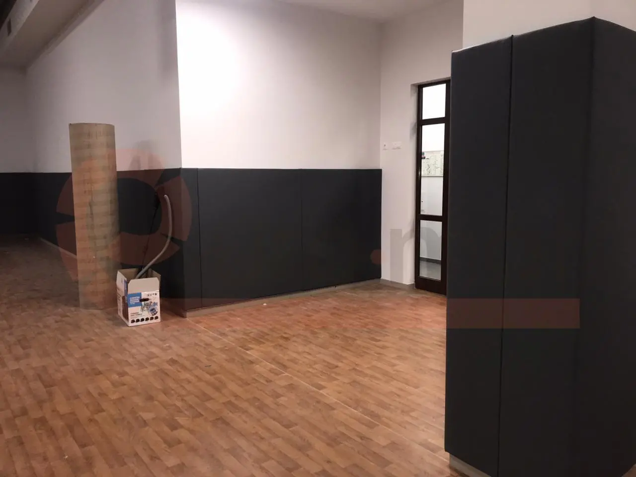 Общий вид школьного спортзала со стеновыми протекторами по периметру, волейбольной сеткой и баскетбольными кольцами