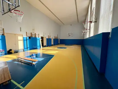 Синие стеновые протекторы в спортзале школы №35 Подольска с жёлто-синим полом и баскетбольными щитами