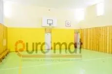 Жёлтые стеновые протекторы в школьном спортзале с баскетбольным щитом