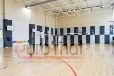 Шахматные стеновые протекторы серо-белые в школьном спортзале с волейбольной сеткой