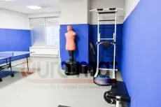 Синие стеновые протекторы в зале с боксёрским манекеном и шведской стенкой