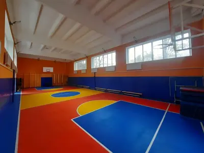 Синие стеновые протекторы в спортзале Железноводска с ярким баскетбольным полом красного, синего и жёлтого цвета