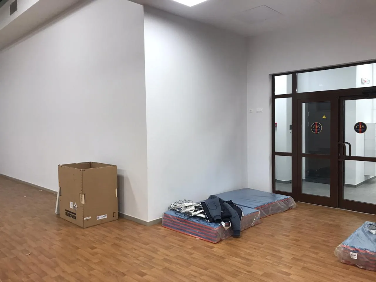 Фото 14: вестибюль спортзала с упакованными стеновыми протекторами готовыми к монтажу