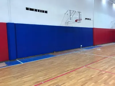Синие и красные стеновые протекторы в баскетбольном зале ЦСКА с кольцом на стене