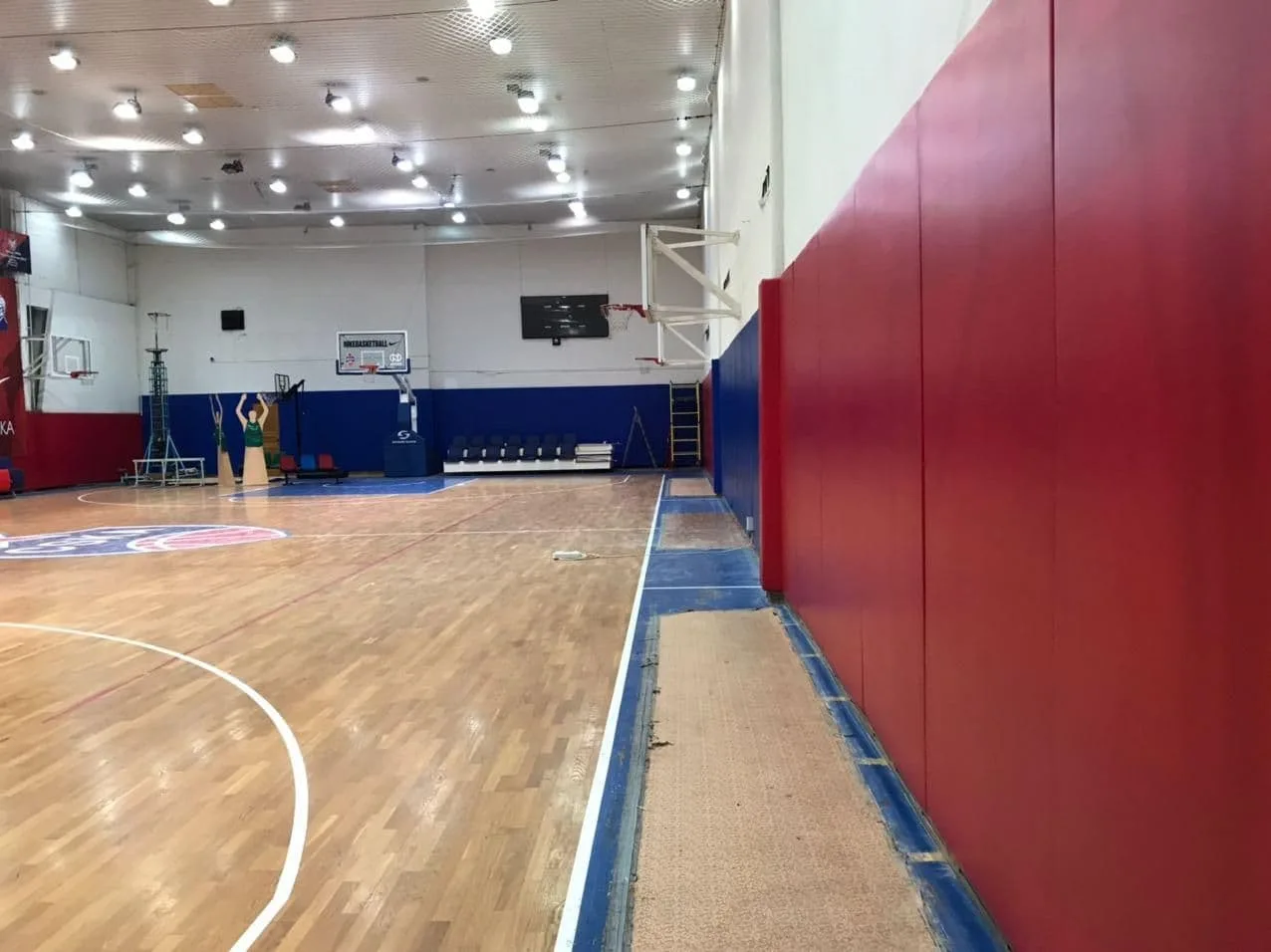 Красные и синие стеновые протекторы вдоль боковой стены баскетбольного зала ЦСКА