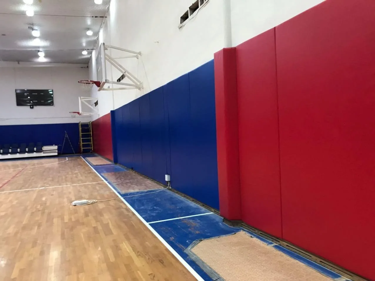 Синие и красные стеновые протекторы с баскетбольным кольцом в зале ЦСКА крупным планом