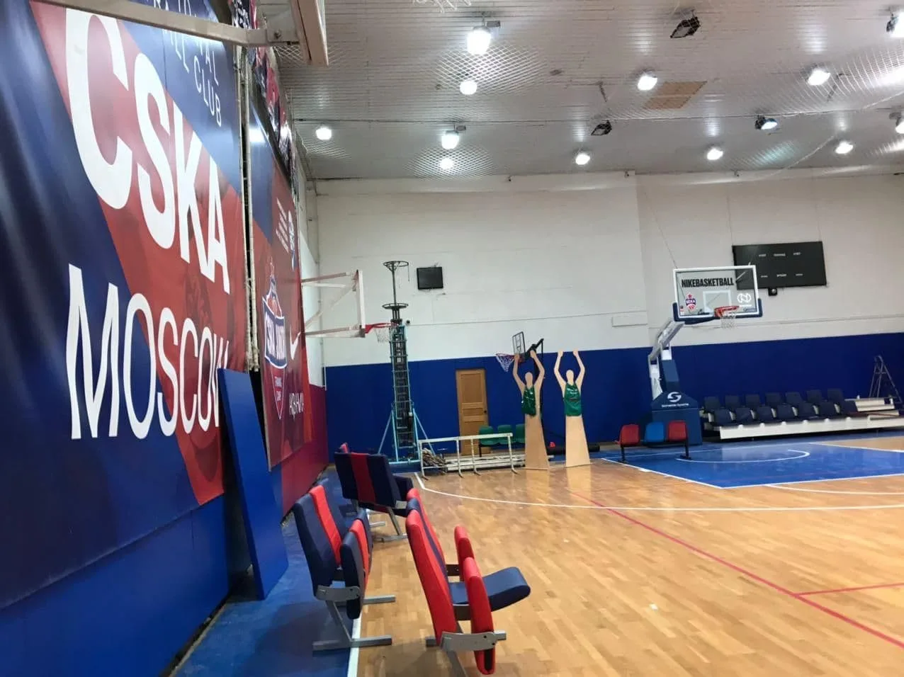 Баннер CSKA Moscow и синие протекторы на стене баскетбольного зала с креслами для зрителей