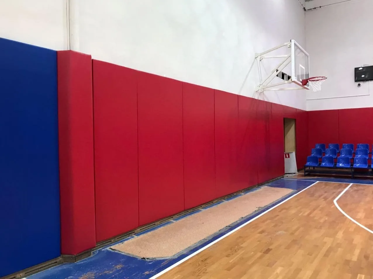 Красные стеновые протекторы вдоль стены с кольцом и синими креслами в зале ЦСКА