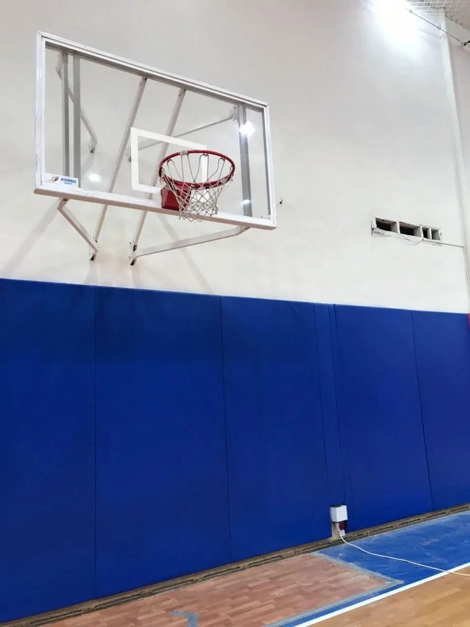 Синие стеновые протекторы под баскетбольным щитом Kenko крупным планом в зале ЦСКА