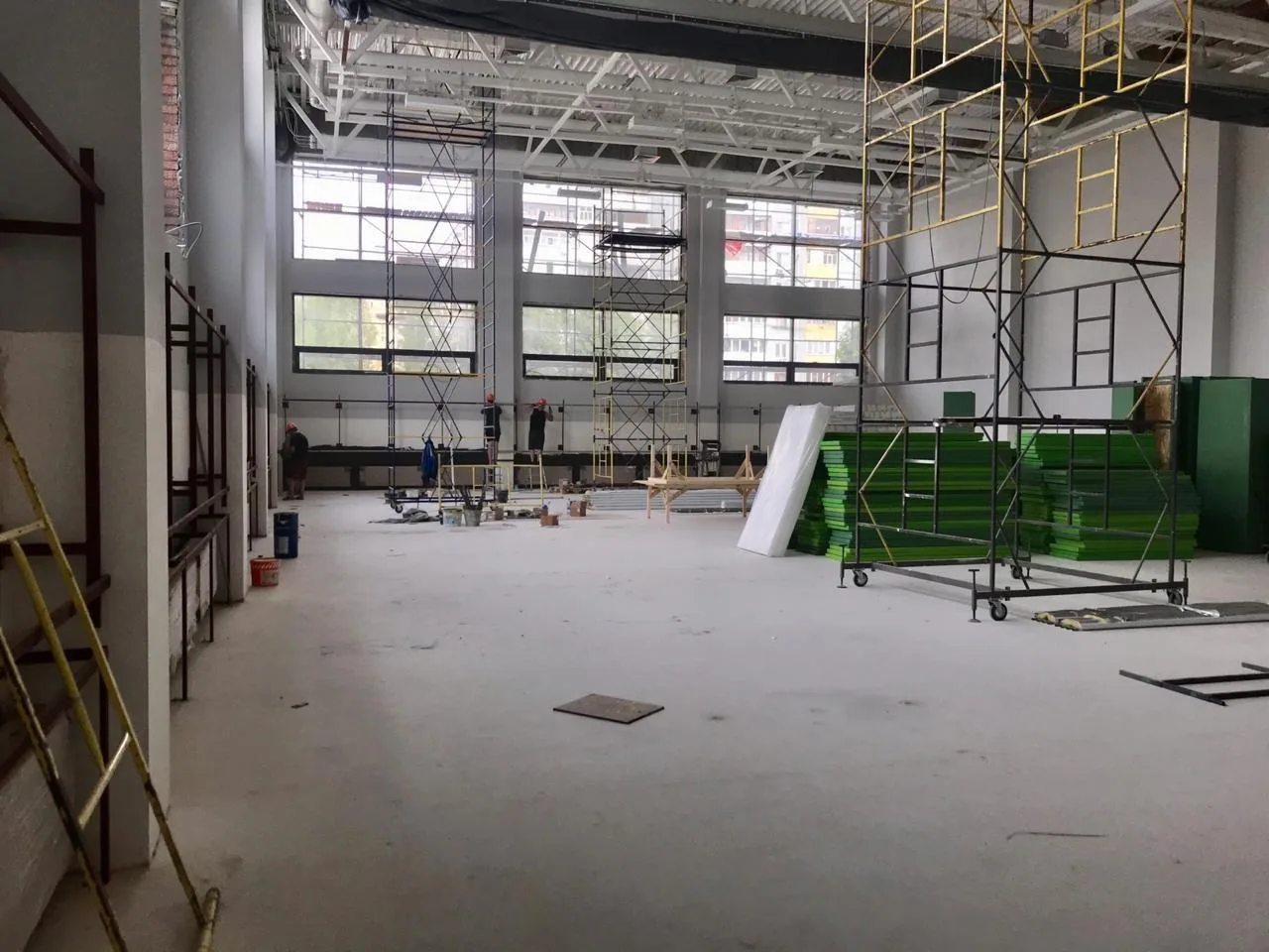 Подготовка к монтажу: стопки зелёных протекторов в школьном зале