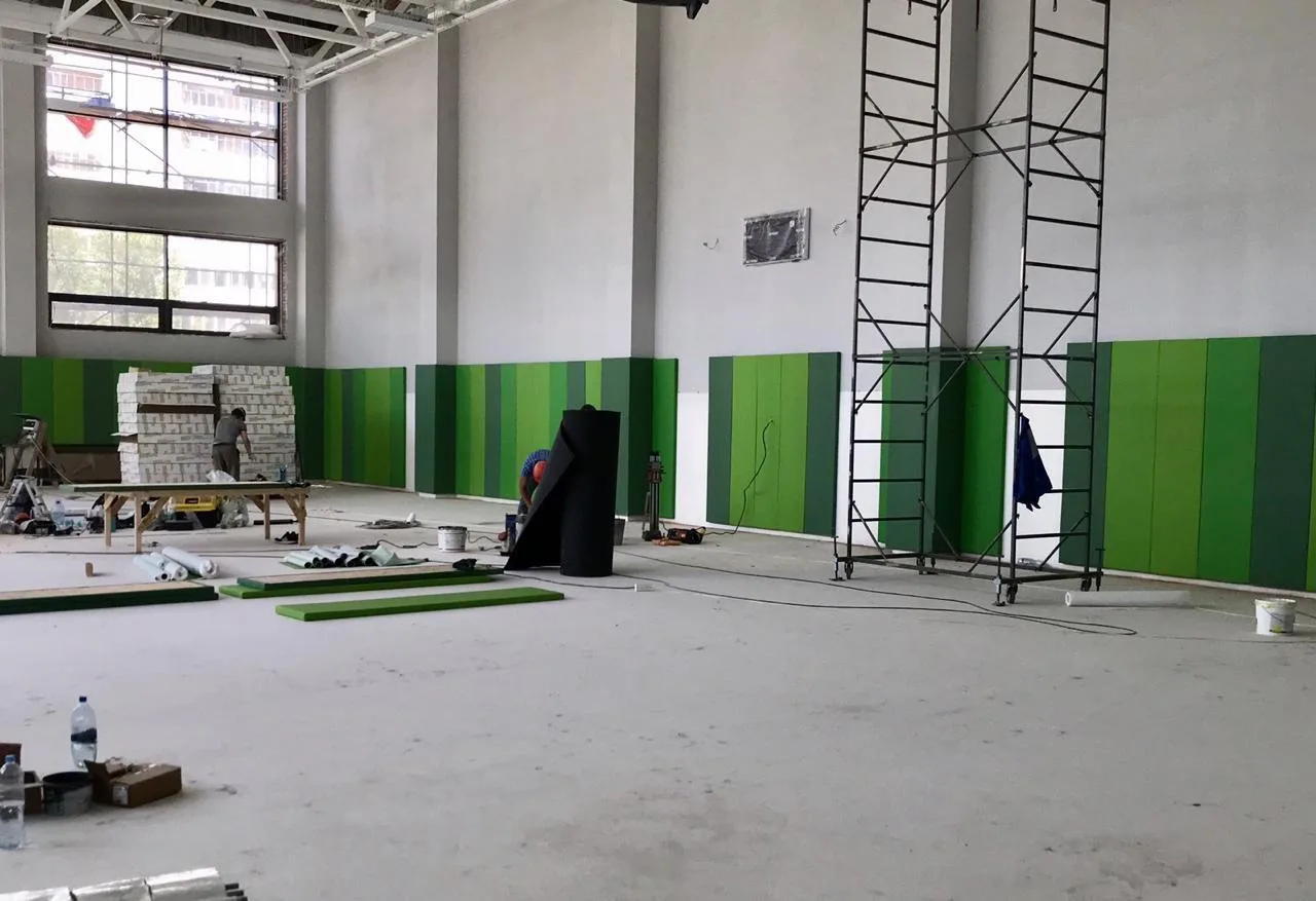 Установленные зелёные стеновые протекторы в чередующихся оттенках вдоль стены зала