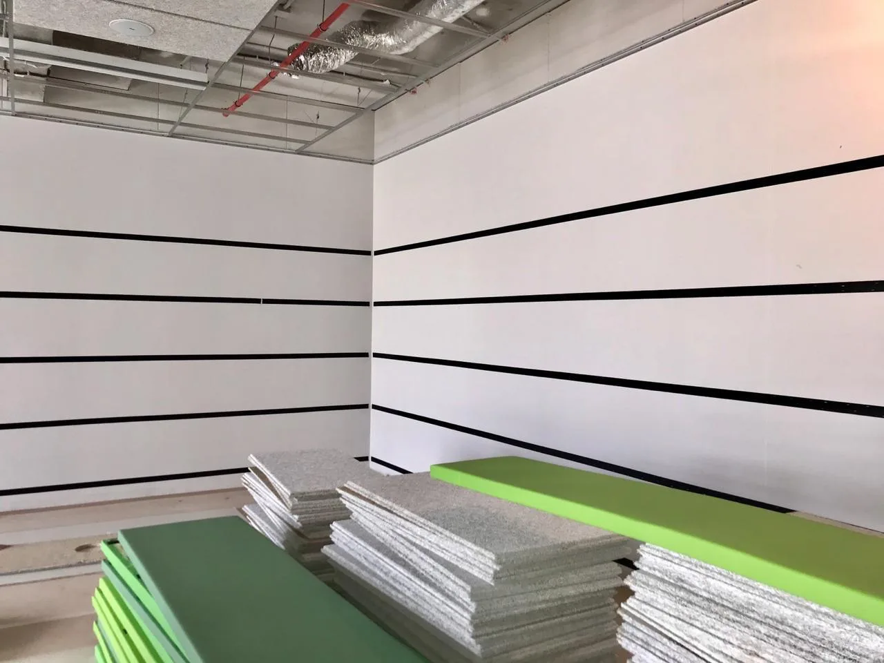 Угол спортзала со стопками панелей и установленными направляющими