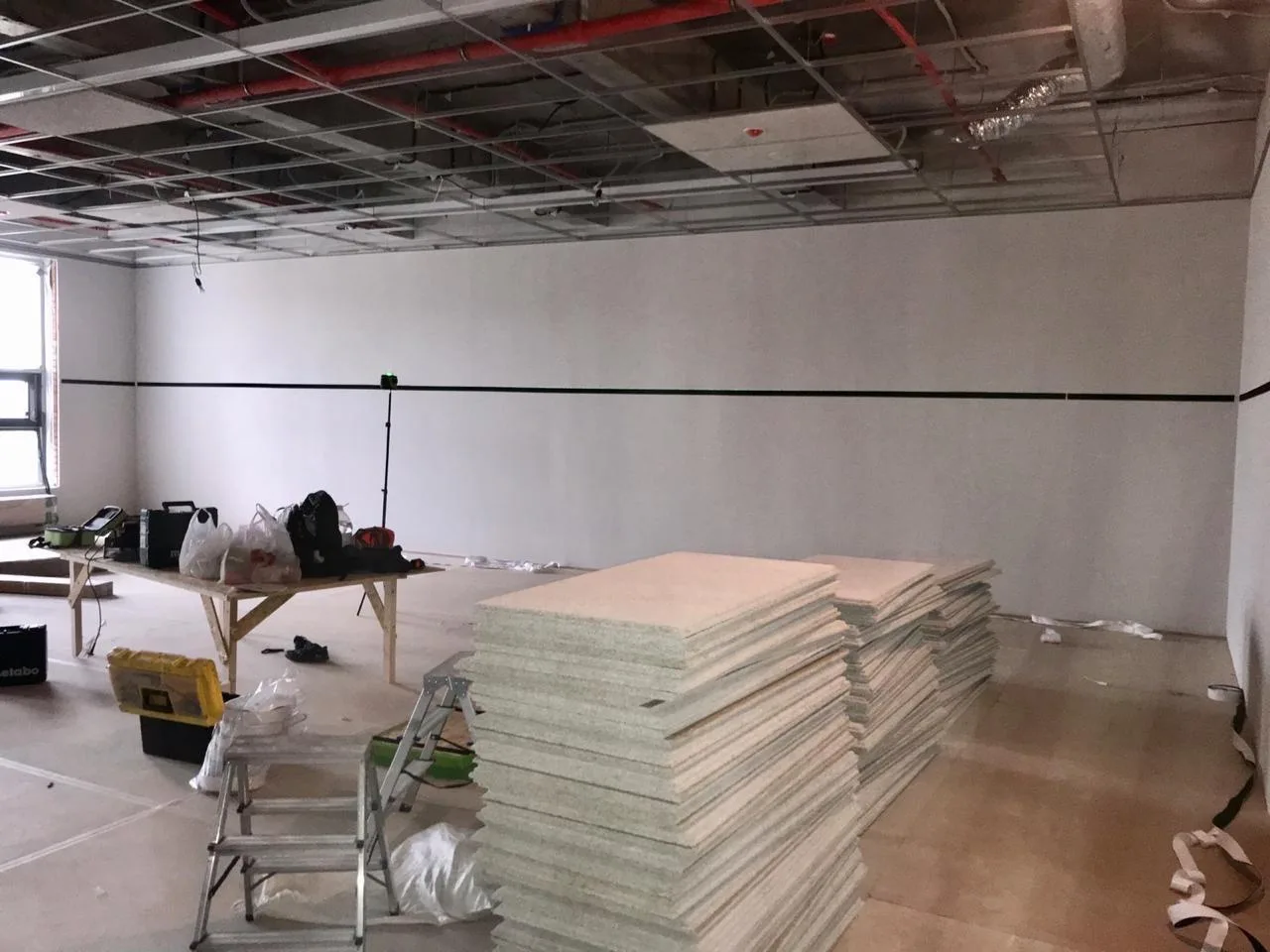 Стопки панелей и направляющие крепления на стене перед монтажом