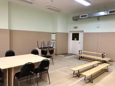 Бежевые стеновые протекторы вокруг двери и скамейки в зале детского сада