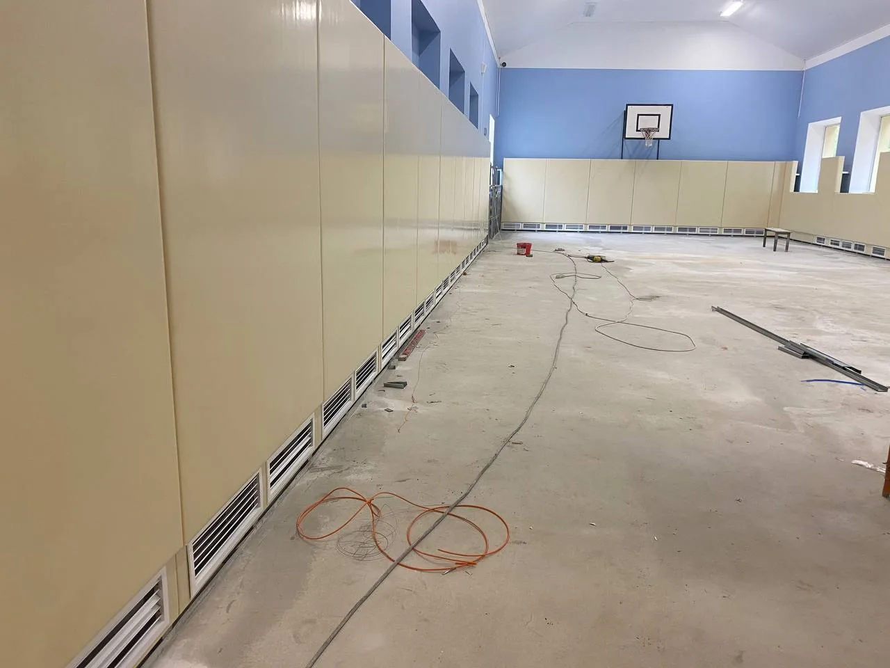 Бежевые стеновые протекторы в школьном спортзале с баскетбольным щитом, монтаж