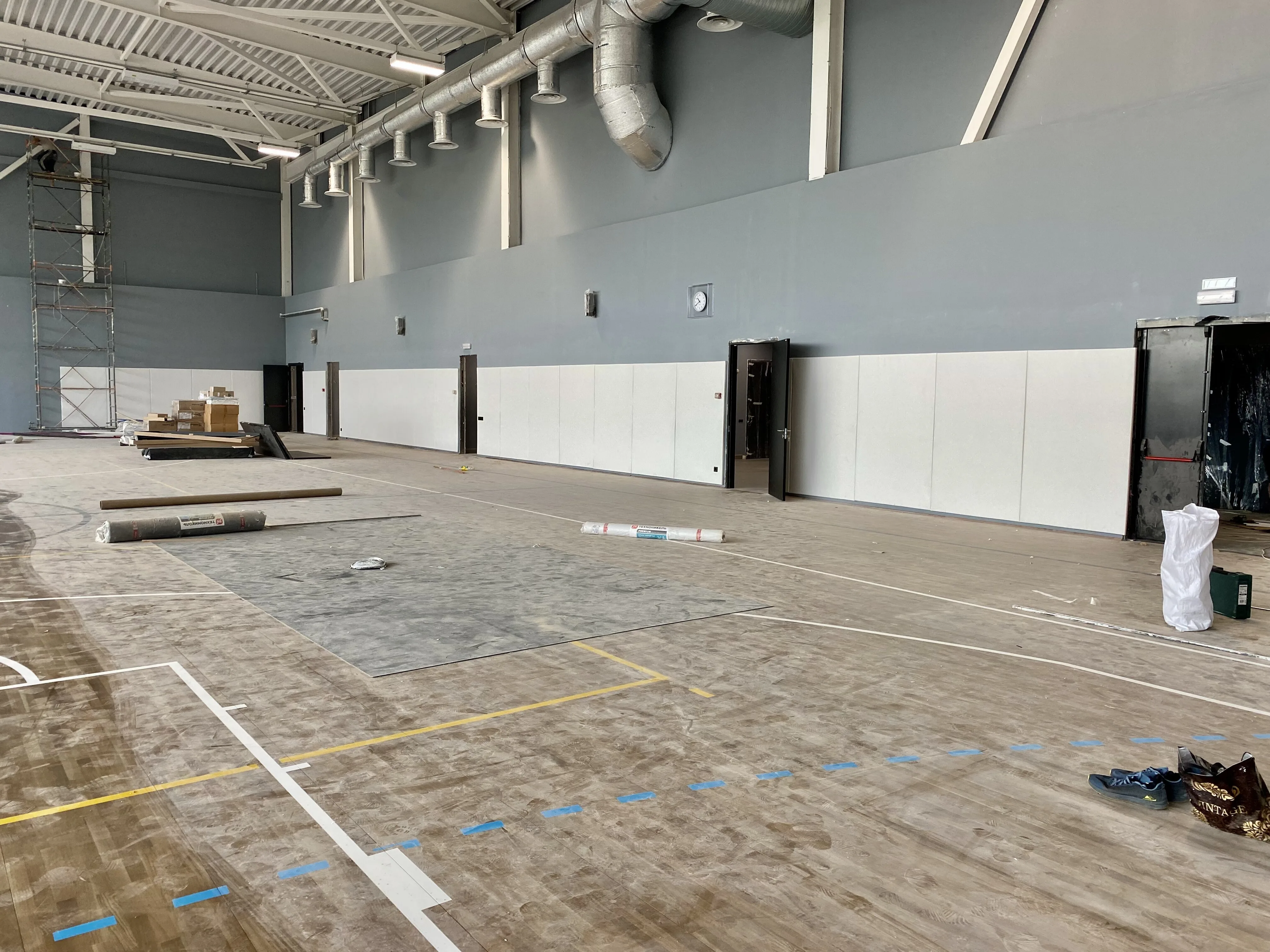 Светлые стеновые протекторы в новом школьном спортзале, процесс монтажа