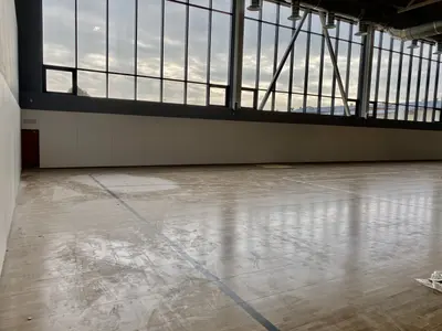 Светлые стеновые протекторы под панорамными окнами школьного спортзала