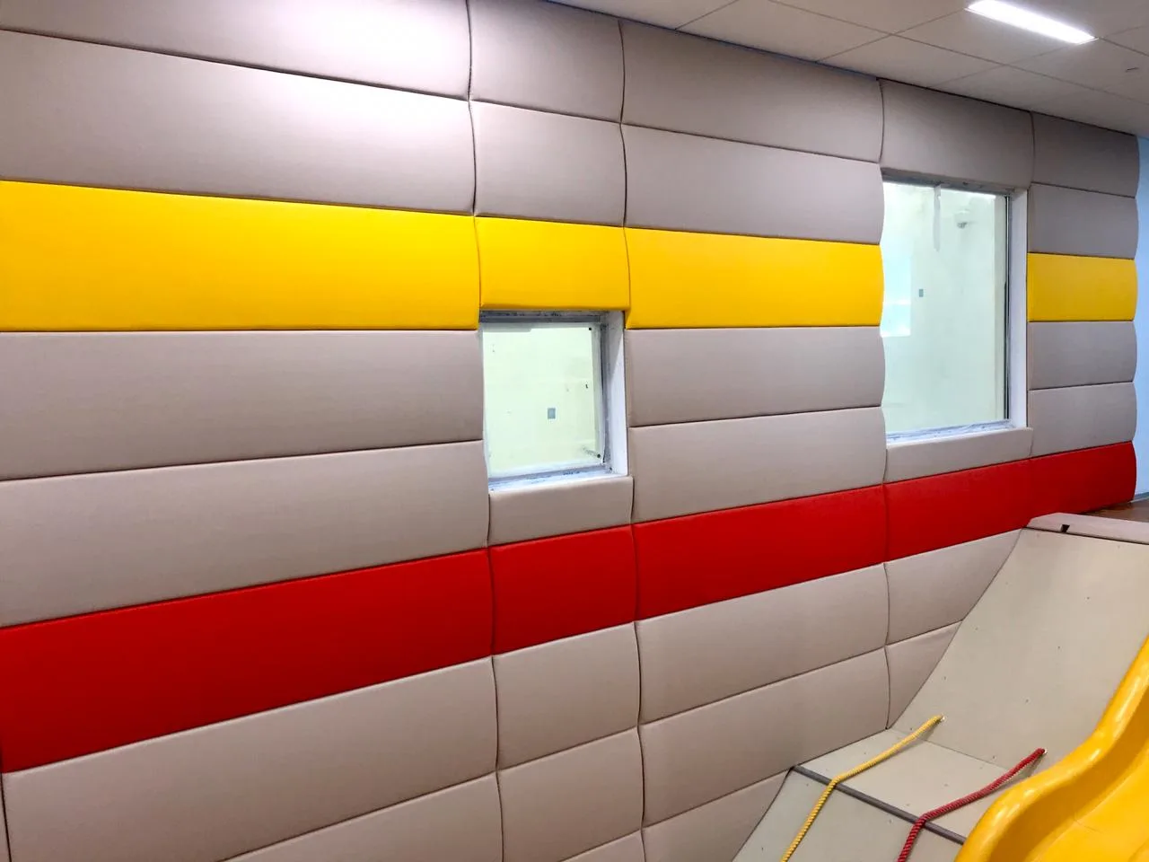 Крупный план выпуклых стеновых протекторов бежевого, жёлтого и красного цвета вокруг окон