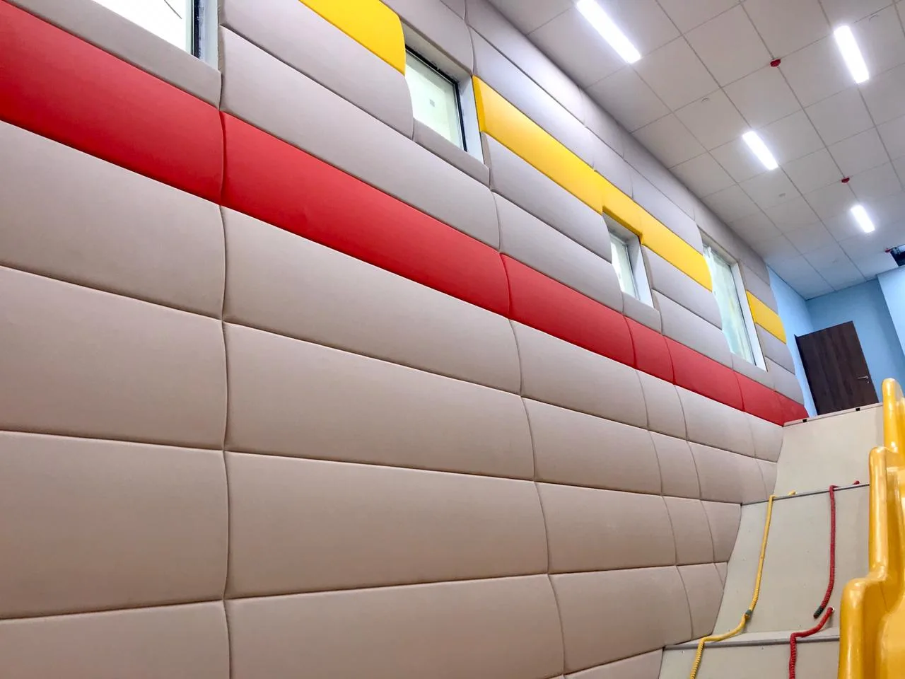 Выпуклые бежевые стеновые протекторы с красными и жёлтыми полосами вдоль длинной стены