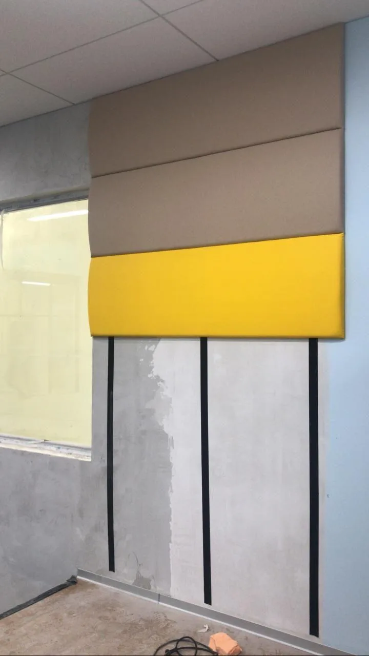 Выпуклый бежево-жёлтый стеновой протектор на углу стены у потолка крупным планом