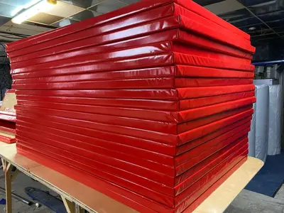 Стопка красных стеновых протекторов из ПВХ на столе производства Евромат