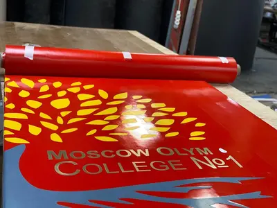 Красный протектор с логотипом Moscow Olympic College №1 крупным планом на производстве
