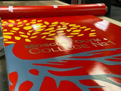 Крупный план логотипа Moscow Olympic College №1 на красном стеновом протекторе