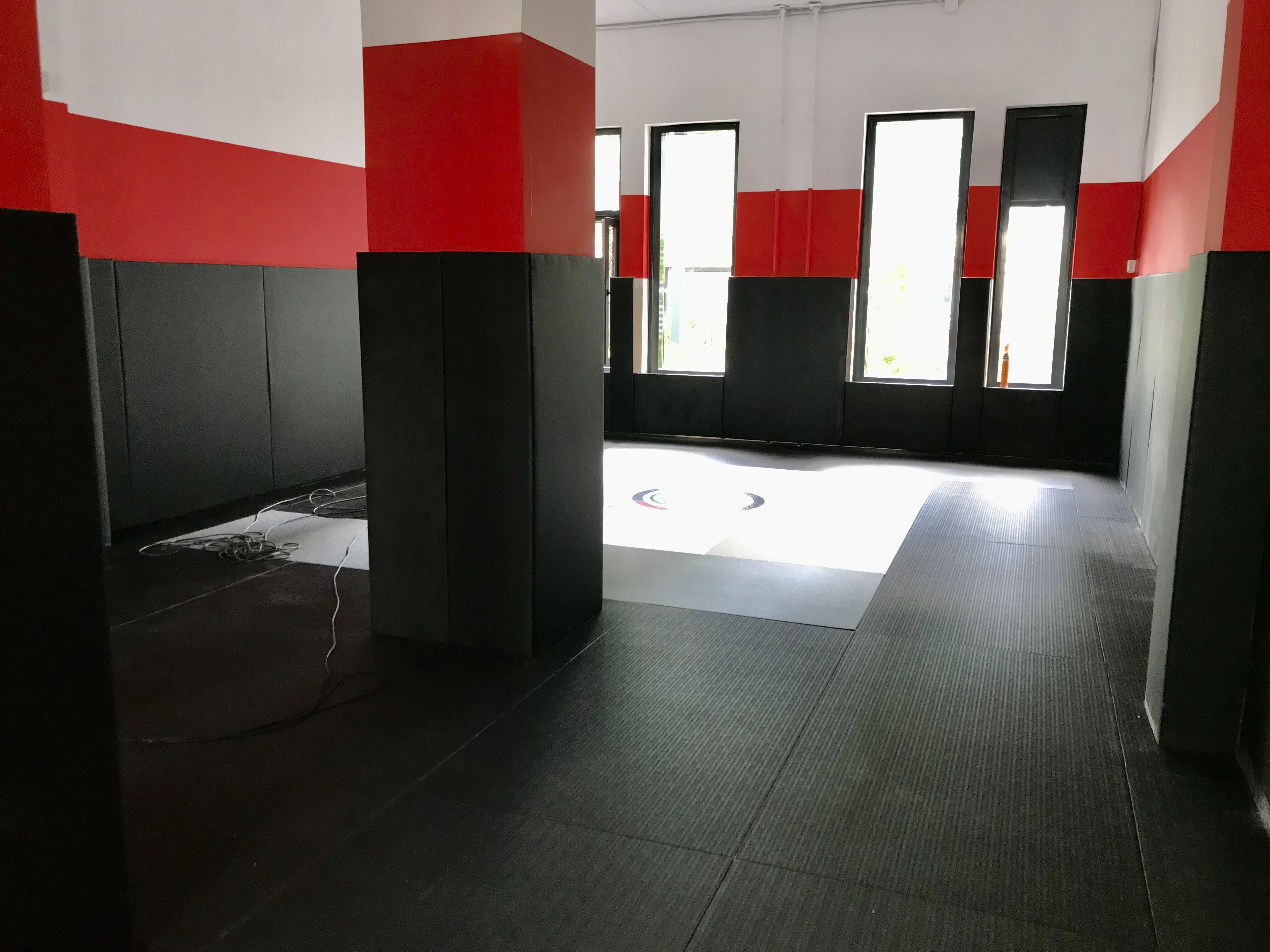 Чёрные татами с джудо тканью и чёрно-красные стеновые протекторы в зале Kaylas Team Junior