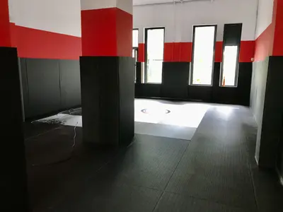 Чёрные татами с джудо тканью и чёрно-красные стеновые протекторы в зале Kaylas Team Junior