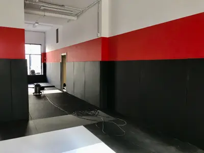 Чёрные татами и красно-чёрные протекторы в зале Kaylas Team Junior — боковой вид