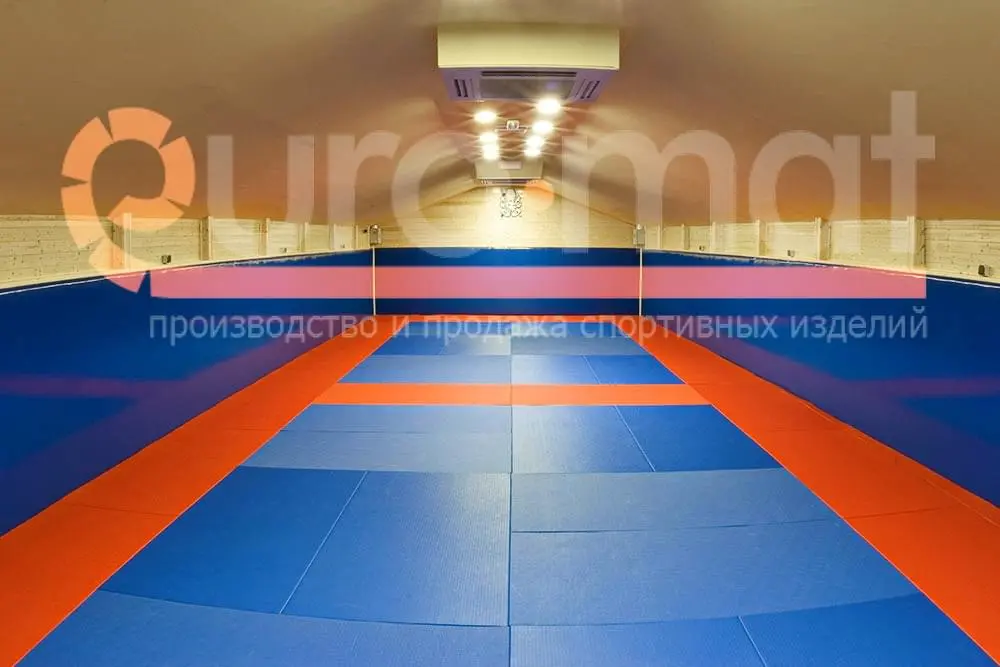 Сине-оранжевые татами и синие стеновые протекторы в зале единоборств